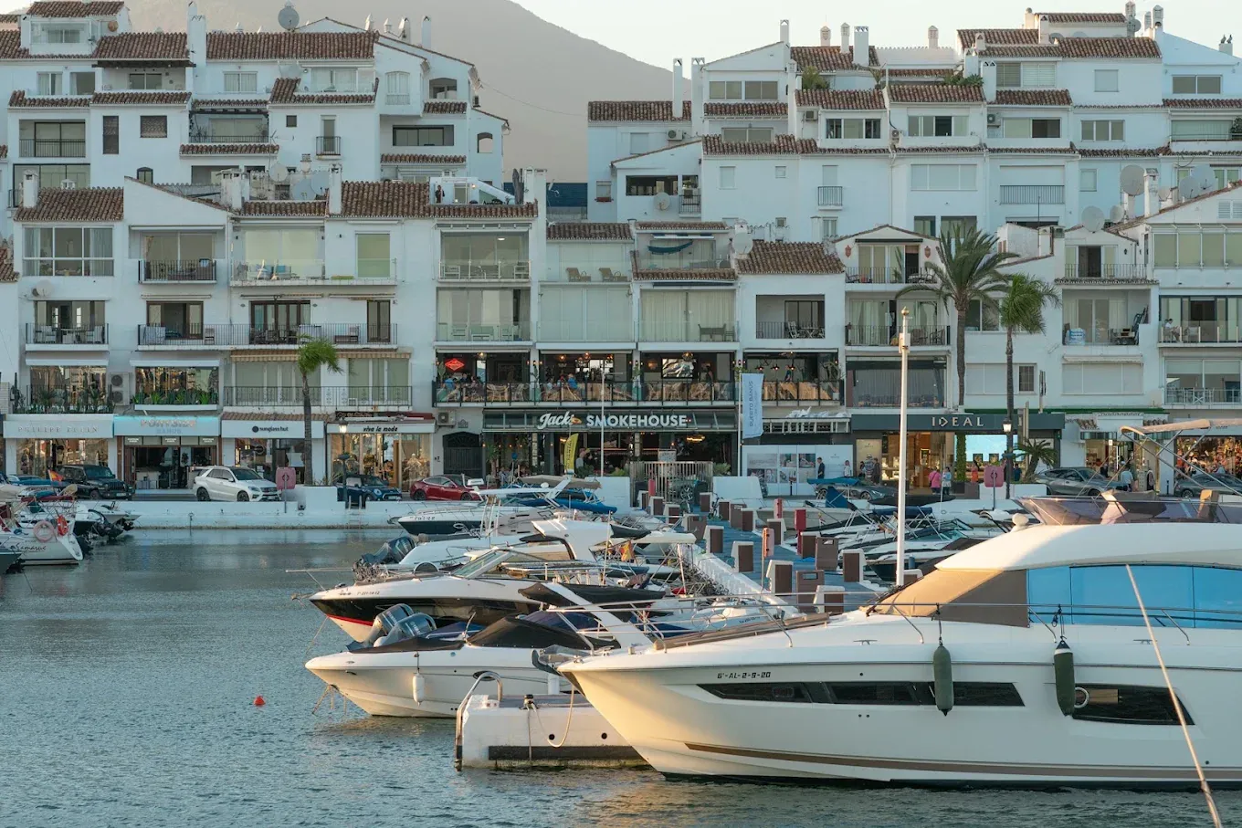 Jack's Smokehouse on the waterfront in Puerto Banús, seen across the yachts at golden hour