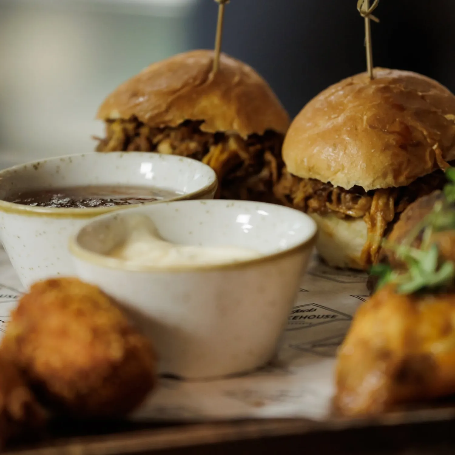 Pulled pork sliders with dips on branded Jack's Smokehouse paper