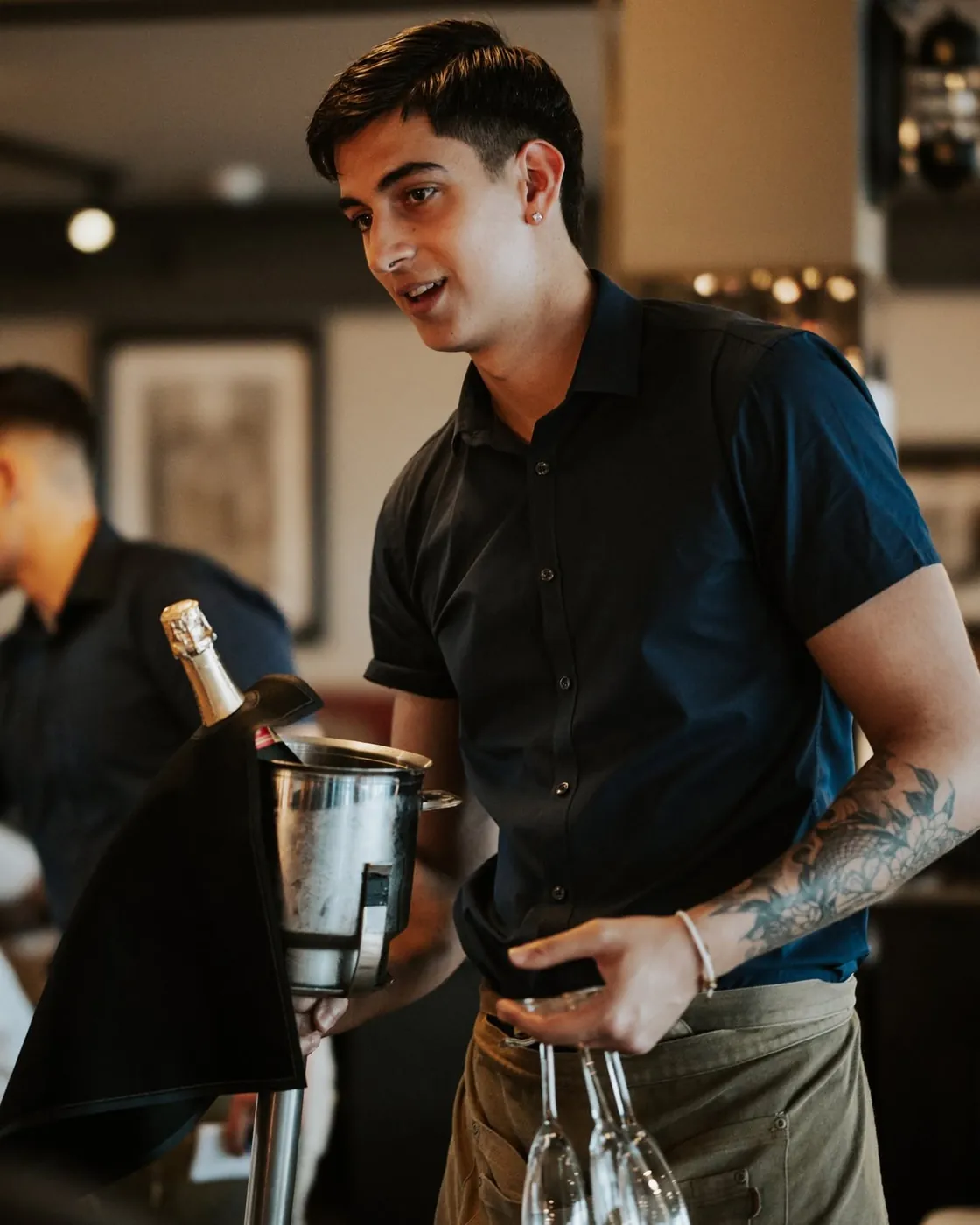 A member of the Jack's team carrying a champagne bucket through the room