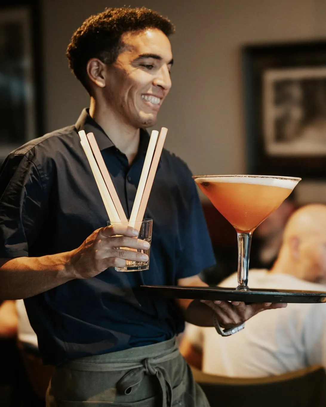 A member of the Jack's team carrying a cocktail on a tray